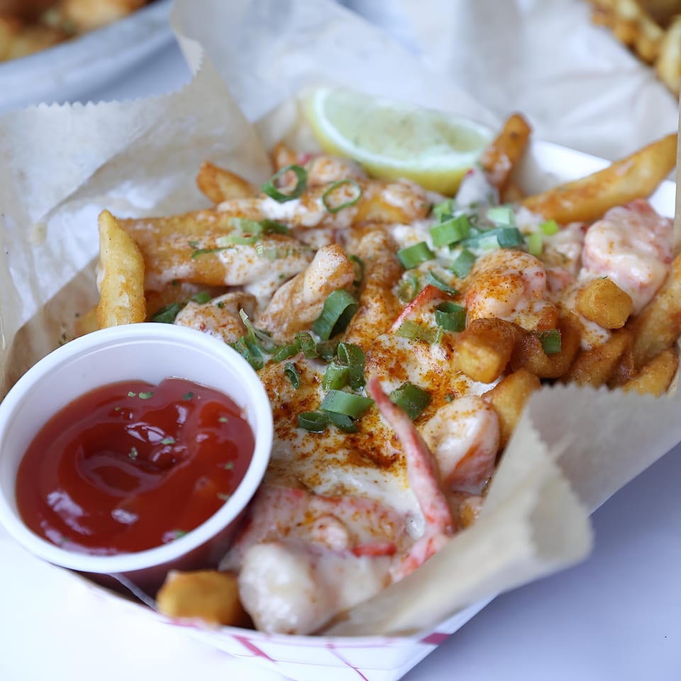 Shaking Crab's Cajun fries with shrimp, sauce, green onions, and a side of ketchup.